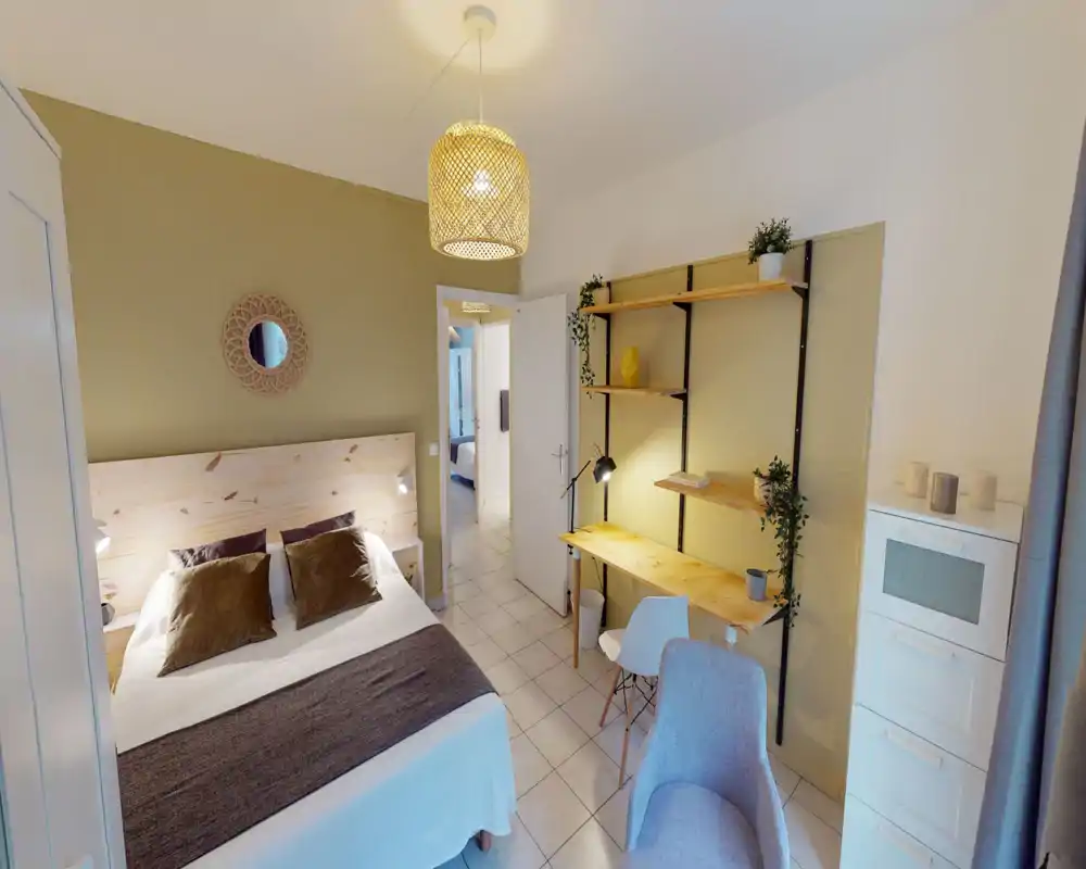 Dormitorio luminoso y bien decorado con cama doble, cabecero de madera, cojines acogedores y un pequeño escritorio con estanterías — ideal para estancias cómodas y teletrabajo.