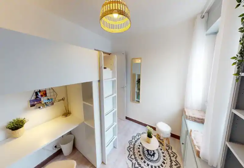 Camera da letto singola luminosa e ben arredata con letto a soppalco/lettino bianco, scrivania integrata e scala, tappeto soffice e cuscini sulla finestra — uno spazio accogliente e funzionale ideale per uno studente o una persona sola.