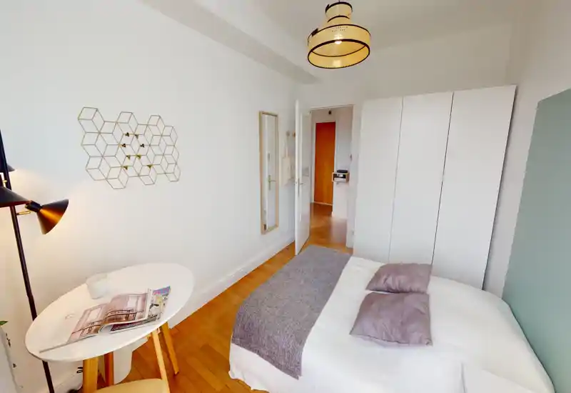 Chambre lumineuse et bien décorée avec lit double, armoire et petite table — parfaite pour un séjour cosy.