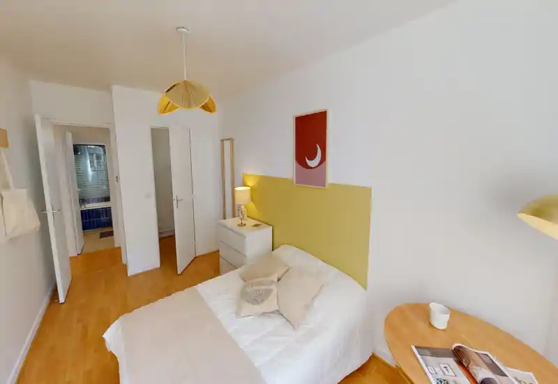 Sunny, well-styled bedroom with a double bed, bedside table and warm lighting; neutral tones and wood floor create a calm, inviting atmosphere.