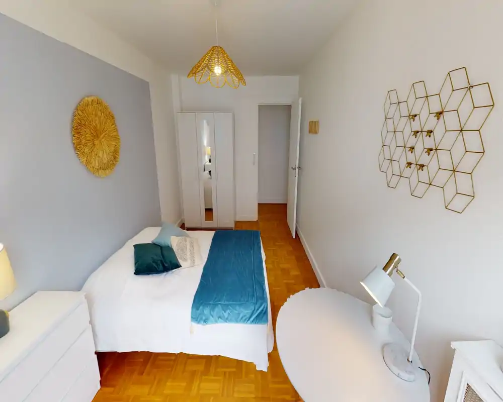Bright, stylish bedroom with a double bed dressed in white linens and teal accents, a wardrobe with mirrored doors and minimalist decor creating a calm, inviting atmosphere.