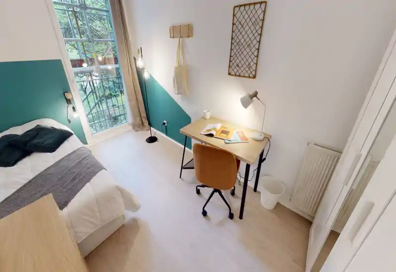 Camera singola luminosa e ben curata con letto comodo, scrivania per lo studio e finestra ampia che guarda il verde — ideale per studenti o professionisti.