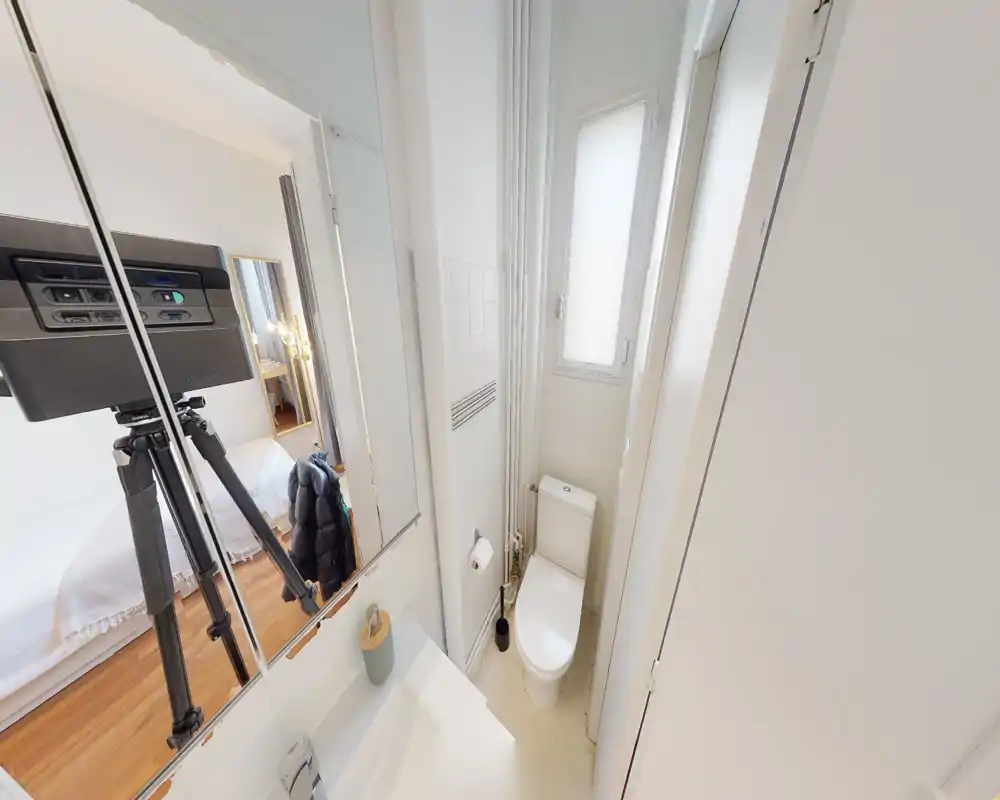 Salle de bains compacte et lumineuse avec WC, vasque et armoire-miroir ; fenêtre dépoli apportant de la lumière naturelle.