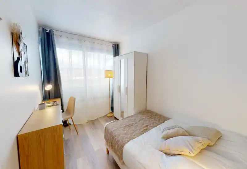 Bright, well-styled single bedroom with a comfortable bed, wardrobe, desk and natural light from a large window — ideal for a student or solo tenant.