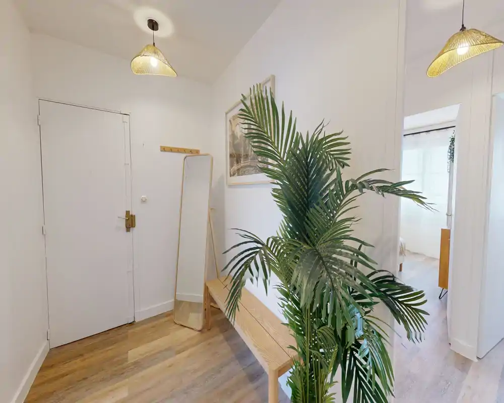 Bright, welcoming entryway with wooden bench, full-length mirror and pendant lighting — neat styling suitable for listing photos.