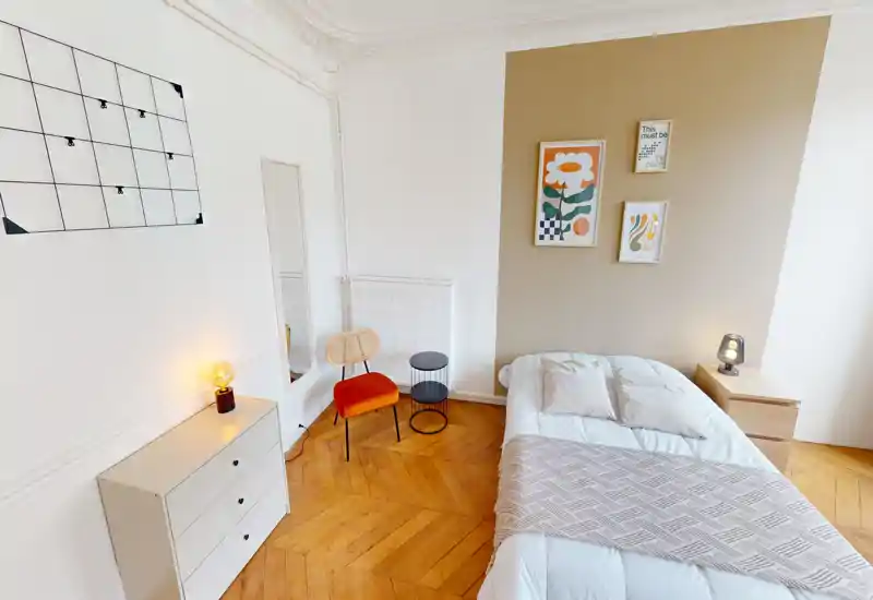 Bright, charming bedroom with a comfortable single/double bed, warm parquet flooring, bedside table and stylish wall art — ideal for a cozy stay.