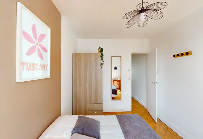 Camera da letto minimale e luminosa con letto ben rifatto, armadio in legno e specchio a figura intera — linee pulite e toni caldi per un ambiente tranquillo e accogliente.