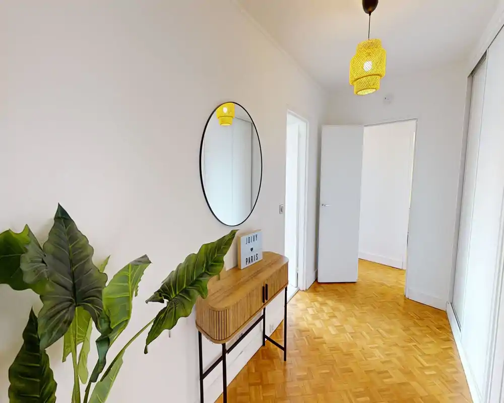 Bright, welcoming entrance hallway with parquet floor, decorative console table, round mirror and a pendant light — ideal first-impression space.