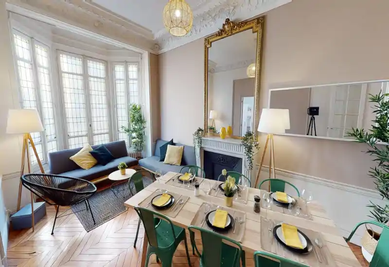 Espace séjour/salle à manger lumineux et élégant avec grande baie vitrée, canapés confortables et table dressée — parfait pour accueillir et visible comme espace de détente et de repas.