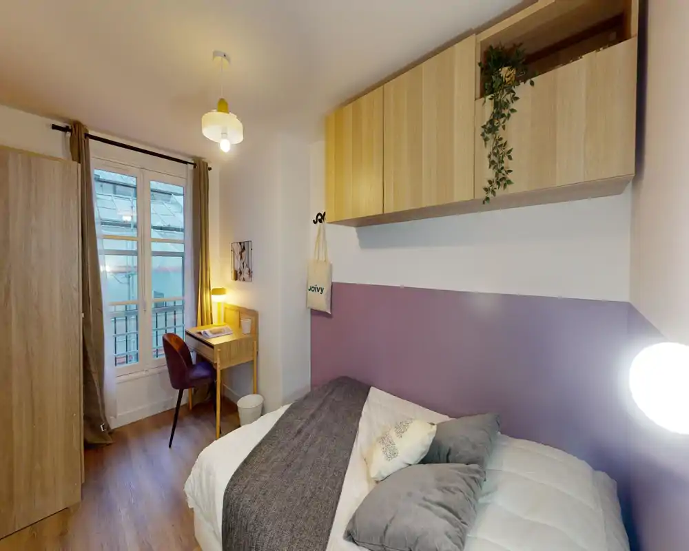 Habitación individual luminosa y acogedora con cama cómoda, textiles suaves y un pequeño escritorio junto a la ventana — ideal para estudiante o profesional.