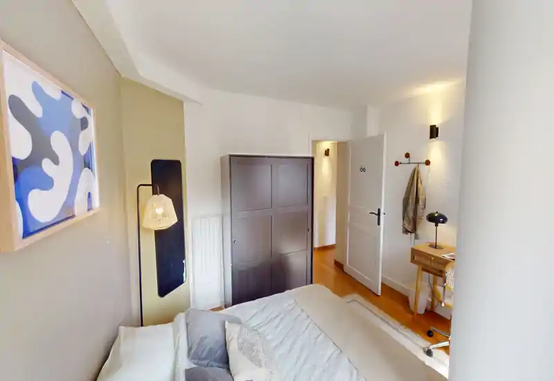 Camera da letto luminosa e ben arredata con letto matrimoniale, biancheria morbida e illuminazione calda che crea un'atmosfera accogliente.