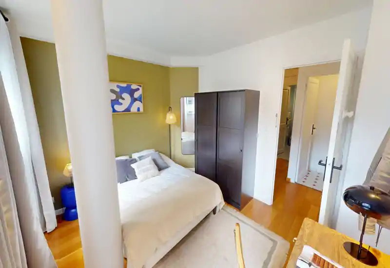 Camera da letto luminosa e di design con un ampio letto, biancheria morbida e arredi contemporanei, completa di armadio e lampade da comodino — perfetta per un soggiorno accogliente.