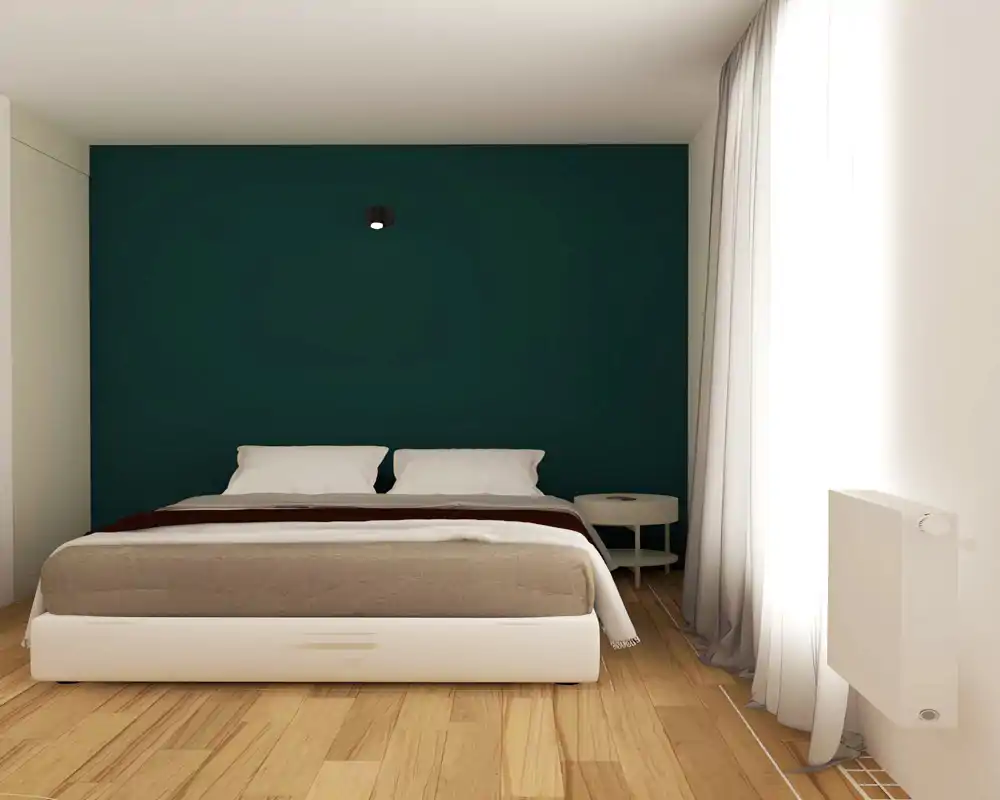 Chambre moderne et lumineuse avec un lit double central placé devant un mur d'accent bleu sarcelle, linge de lit doux et une table de chevet minimaliste — un espace de sommeil calme et bien éclairé.