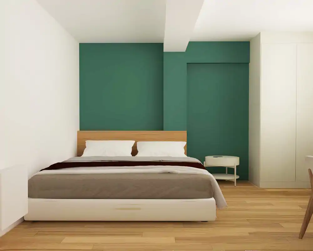 Chambre moderne et lumineuse avec tête de lit en bois devant un mur vert profond, lit double bien fait et petite table de chevet ronde — style épuré, idéal pour les annonces locatives.