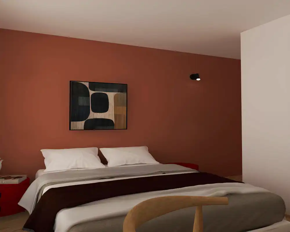 Chambre chaleureuse et soignée avec un lit bien fait, un plaid texturé et une œuvre abstraite accrochée sur un mur terre cuite. L’ensemble est cosy et bien composé, idéal pour une annonce locative.