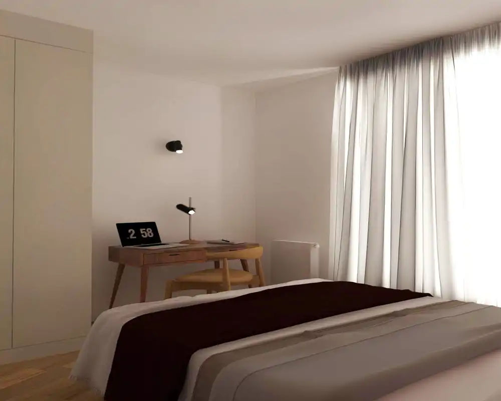 Chambre épurée et lumineuse avec lit au premier plan, bureau et chaise en bois près de la fenêtre, éclairage naturel doux filtré par de longs rideaux.