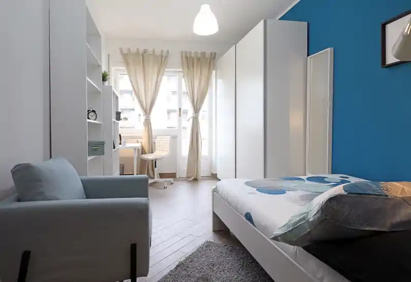 Bright, modern bedroom with a comfortable single bed, soft textiles and a study corner by the window — ideal for a student or solo traveler.