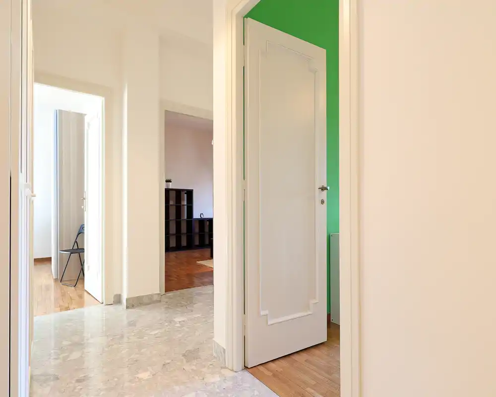 Bright, clean entrance hallway with marble flooring and multiple doorways leading to adjacent rooms, showing good natural light and neutral walls.