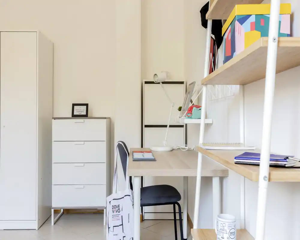 Rincón de estudio luminoso y ordenado con escritorio, silla, estanterías y almacenaje — ideal para trabajar o estudiar en un espacio compacto.