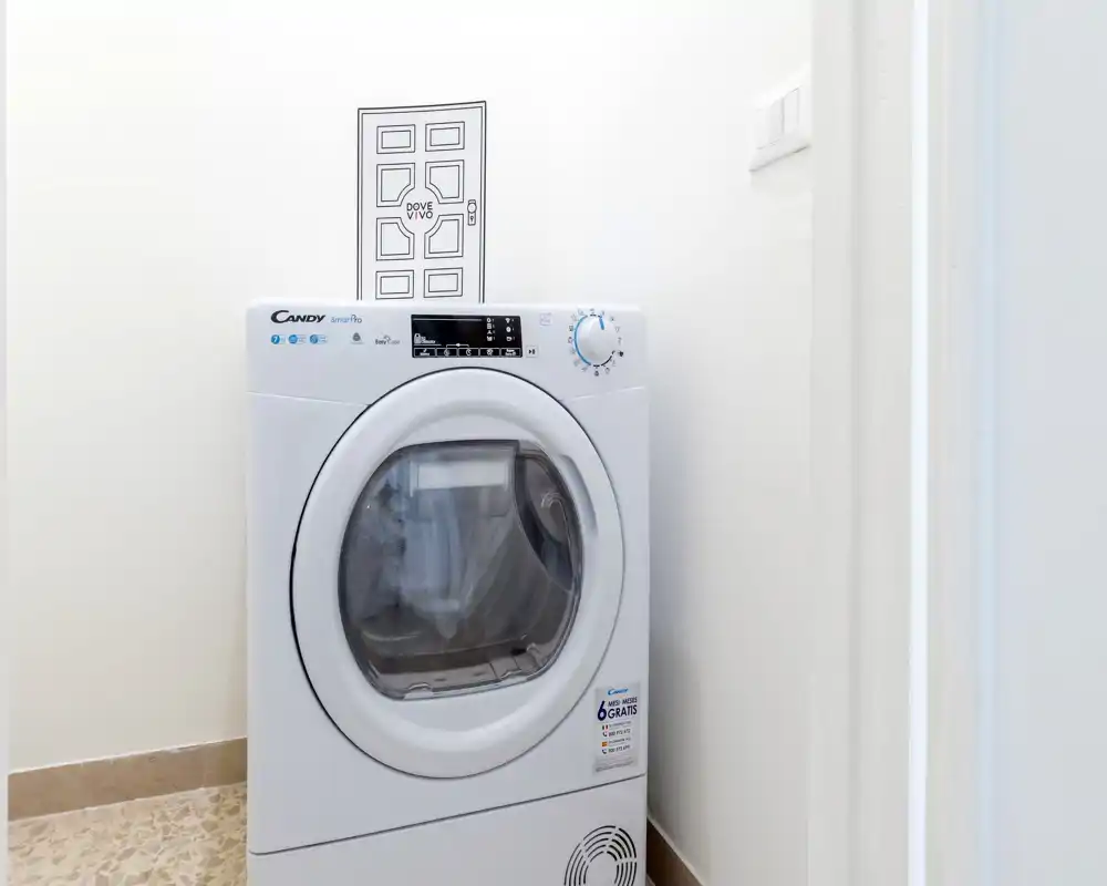 Rincón de lavandería compacto con lavadora de carga frontal en un espacio blanco y luminoso; perfecto para destacar en el anuncio como lavadora en la vivienda.