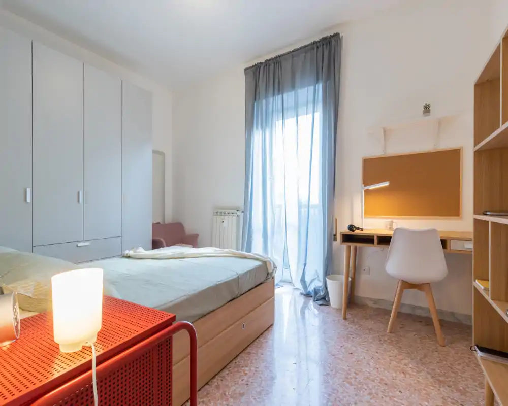 Dormitorio moderno y luminoso con cama doble, armario empotrado, zona de estudio y acceso al balcón. Líneas limpias y luz natural, perfecto para alquileres o estudiantes.