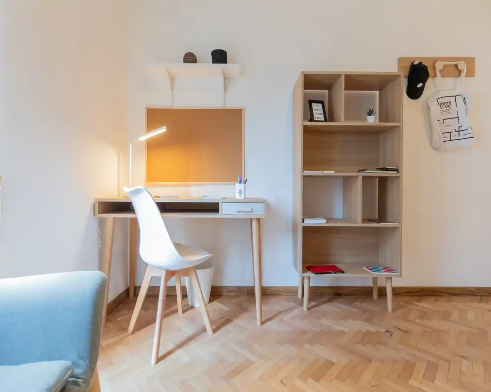 Bright, minimalist study corner with a wooden desk, modern chair and shelving — a calm workspace integrated into a living area.