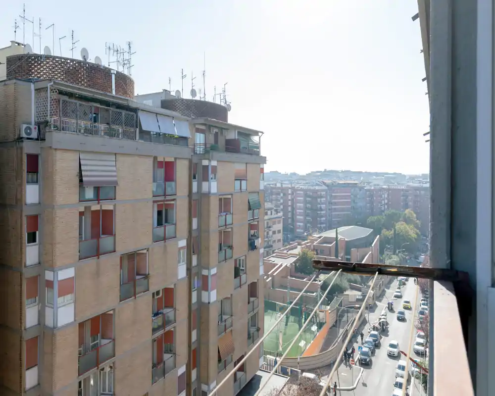 Vista desde el balcón hacia bloques de apartamentos y una calle de la ciudad, con buena luz y un panorama abierto — ideal para mostrar la orientación exterior del piso.