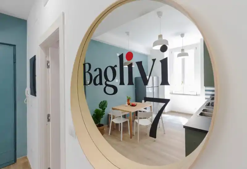 Cuisine moderne et lumineuse avec petite table à manger, chaises simples, plante en pot et grande fenêtre apportant une belle lumière naturelle — agencement pratique pour la location.