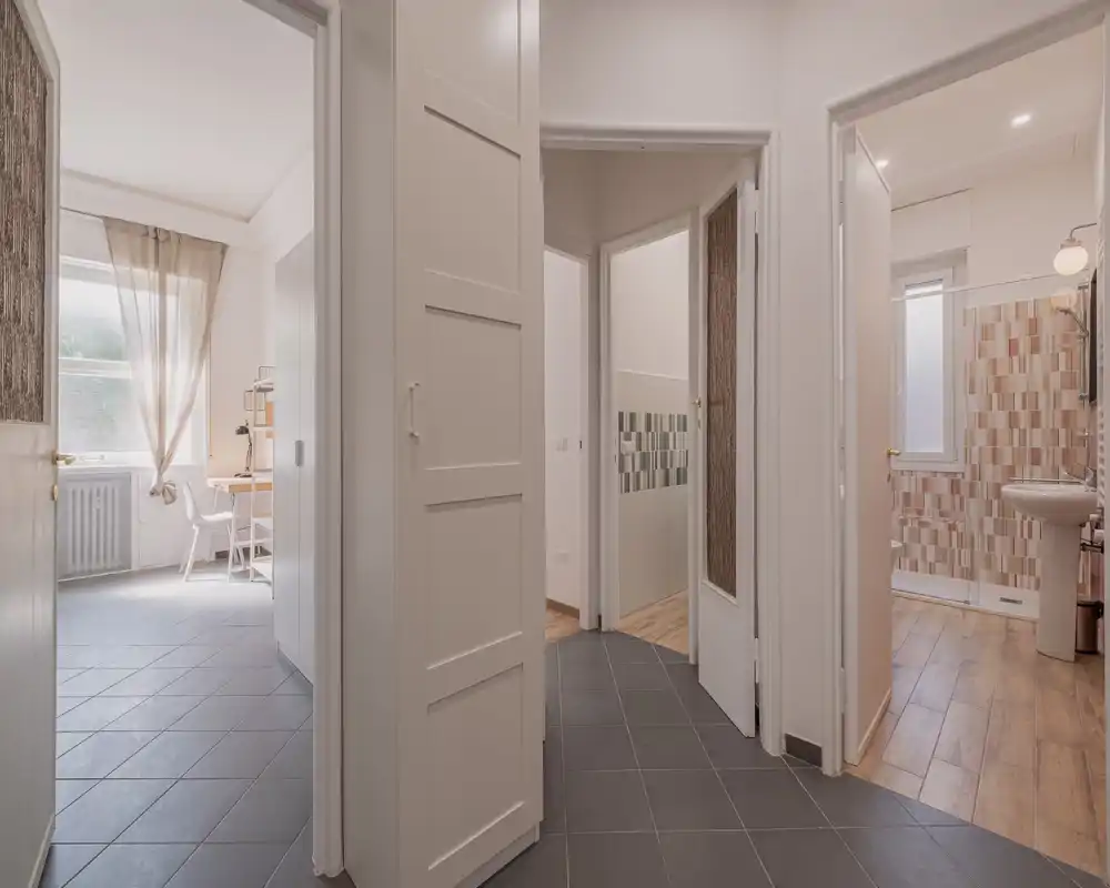 Bright, well-lit entrance/hallway with tiled floor and doors leading to bathroom and other rooms, offering a clear first impression.