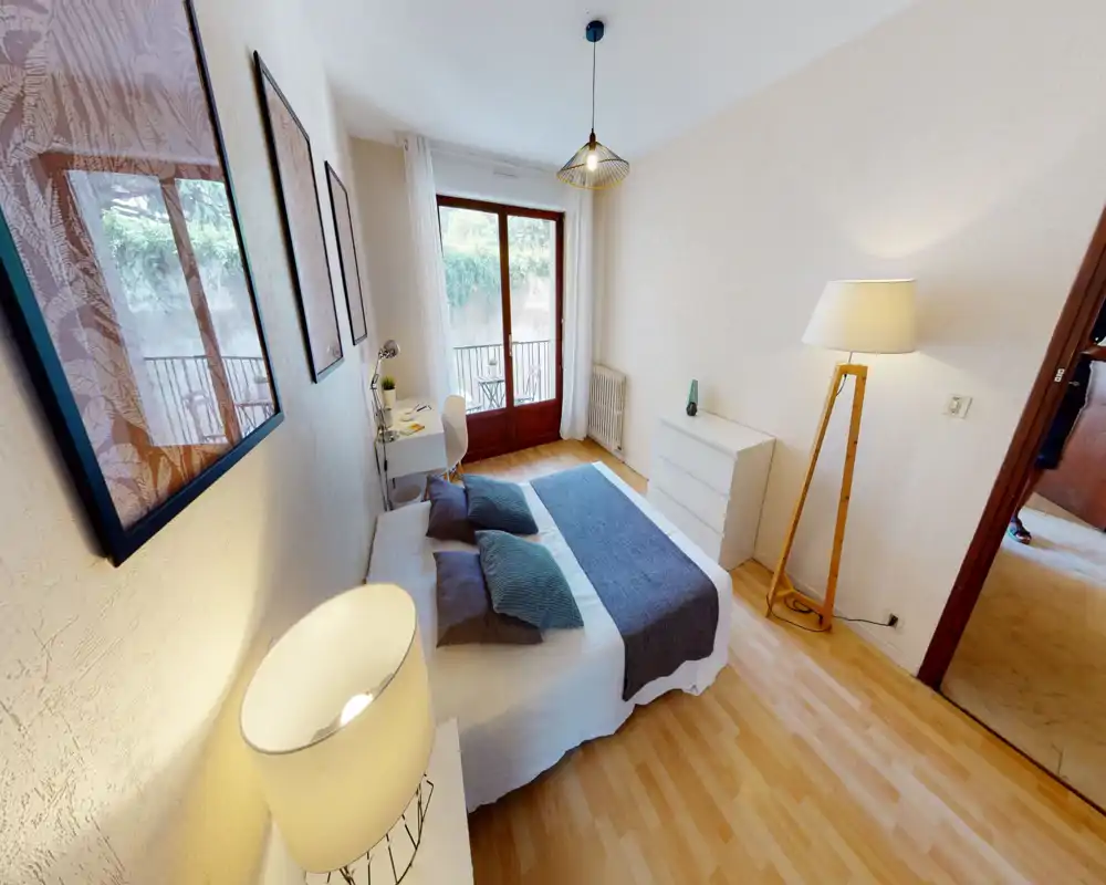 Bright, well-styled bedroom with a double bed, bedside lamps, desk and balcony access. Soft textiles and warm lighting create a comfortable, inviting atmosphere ideal for rentals.