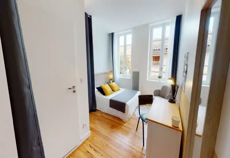 Bright, well-styled bedroom with a double bed, cozy textiles and large windows letting in natural light — ideal for a short-stay listing.