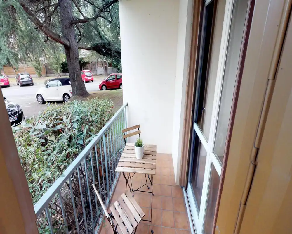 Area esterna visibile nonostante la forte corruzione dell'immagine: si intravedono una siepe e auto parcheggiate, suggerendo un terrazzo o balcone con affaccio su strada o giardino. Immagine molto danneggiata.