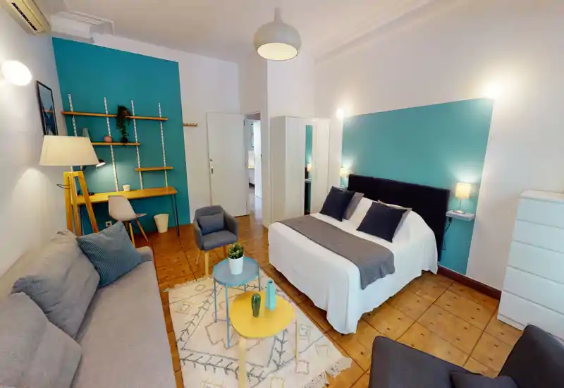 Bright, stylish bedroom with a double bed, bedside lamps, wardrobe and a cozy seating area — ideal for a comfortable stay.