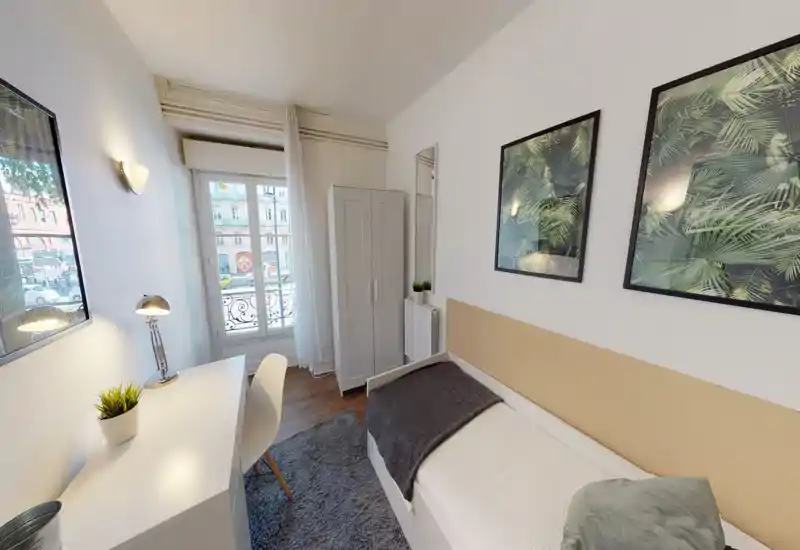 Bright, well-staged single bedroom with a neatly made bed, a desk by the window and modern framed artwork — ideal for a student or single renter.