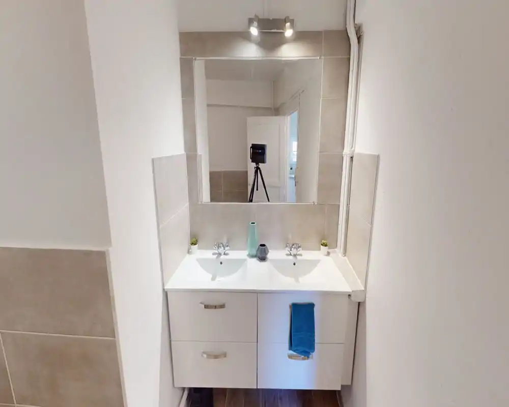 Bagno moderno e luminoso con doppio lavabo, grande specchio e piastrelle neutre — pulito e dallo stile essenziale, ideale per un annuncio.