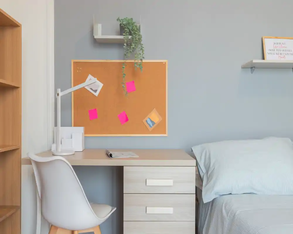 Bright, neatly staged bedroom corner with a single bed and adjacent study desk—ideal for a student or single tenant.