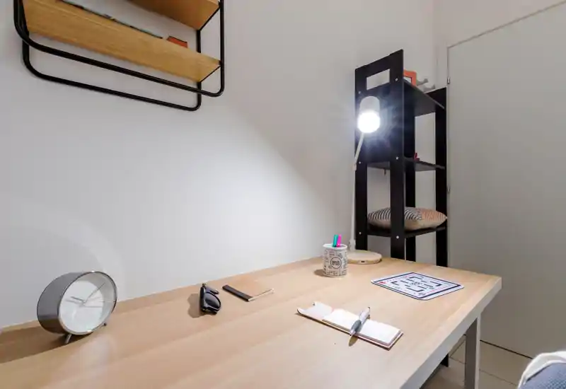 Bright, modern study corner with a wooden desk, task lamp, shelving and a tidy layout—ideal for focused work or studying.