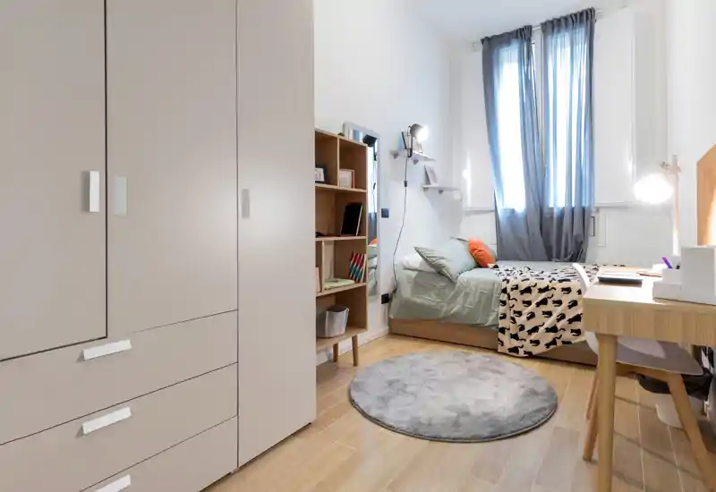 Chambre simple lumineuse et bien agencée avec lit, bureau et armoire; tapis moelleux et tons apaisants, parfaite pour un étudiant ou un séjour court.
